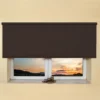 Dark brown light filtering roller blind fitted above a recessed window, sunset view
