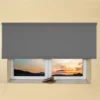 Grey light filtering roller blind fitted above a recessed window, with a sunset view