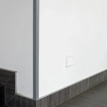 Dark Gray PVC Corner Protector on an External Corner, Hallway, 1m Dark Gray PVC wall corner protector angle trim fitted to a corner above tiled skirting