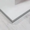 Gray PVC Angle Trim on a Plinth Edge, 1m Corner Protector Gray PVC angle trim installed horizontally on the outer edge of a raised white plinth